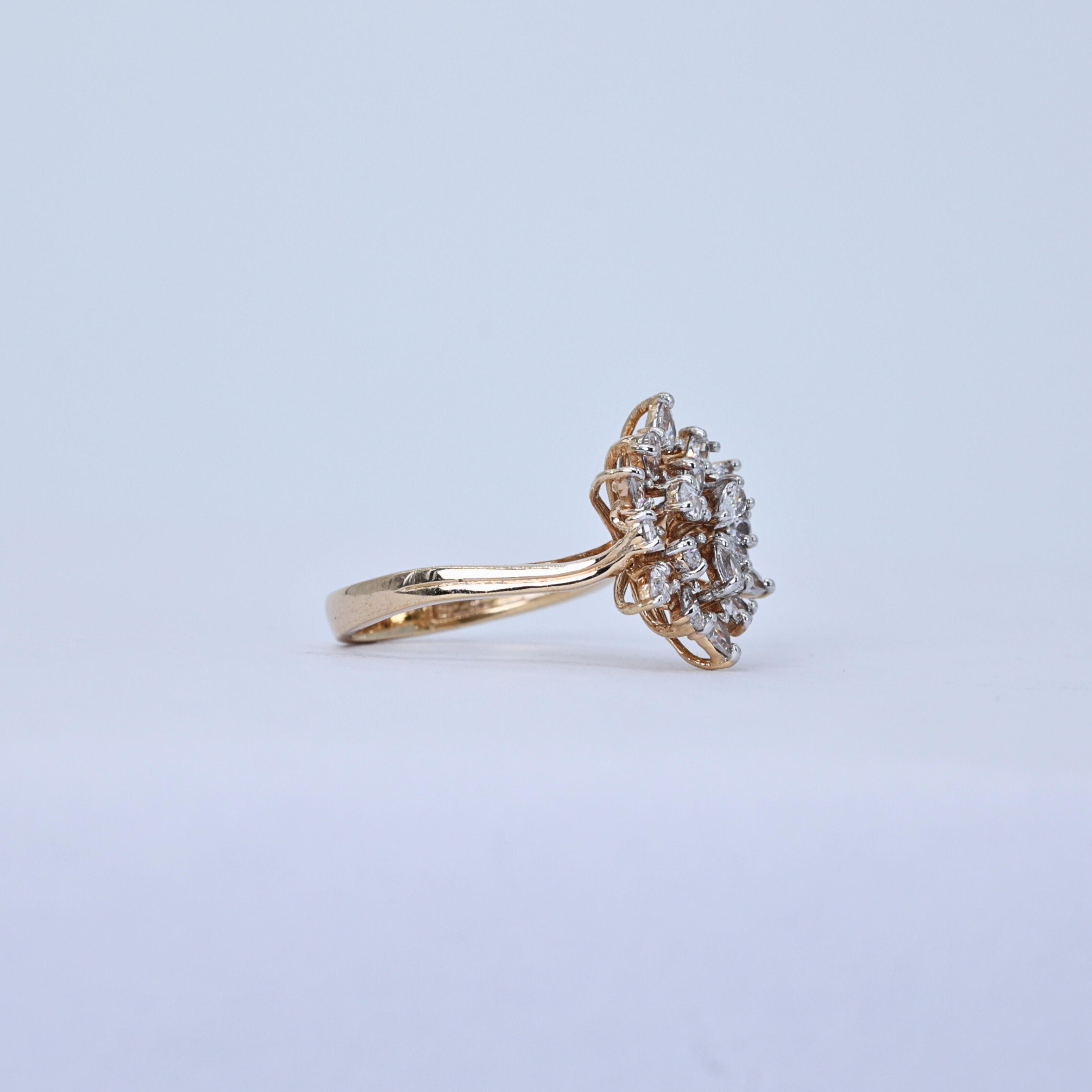 Gold band with cluster diamonds
Elegant ring for proposal
Starburst ring close angle
Modern cluster design ring
Shimmering diamond ring top view
Center cluster on gold band
Halo and band diamond ring
Diamond cluster ring display
Round diamond cluster ring
Square cut center diamond