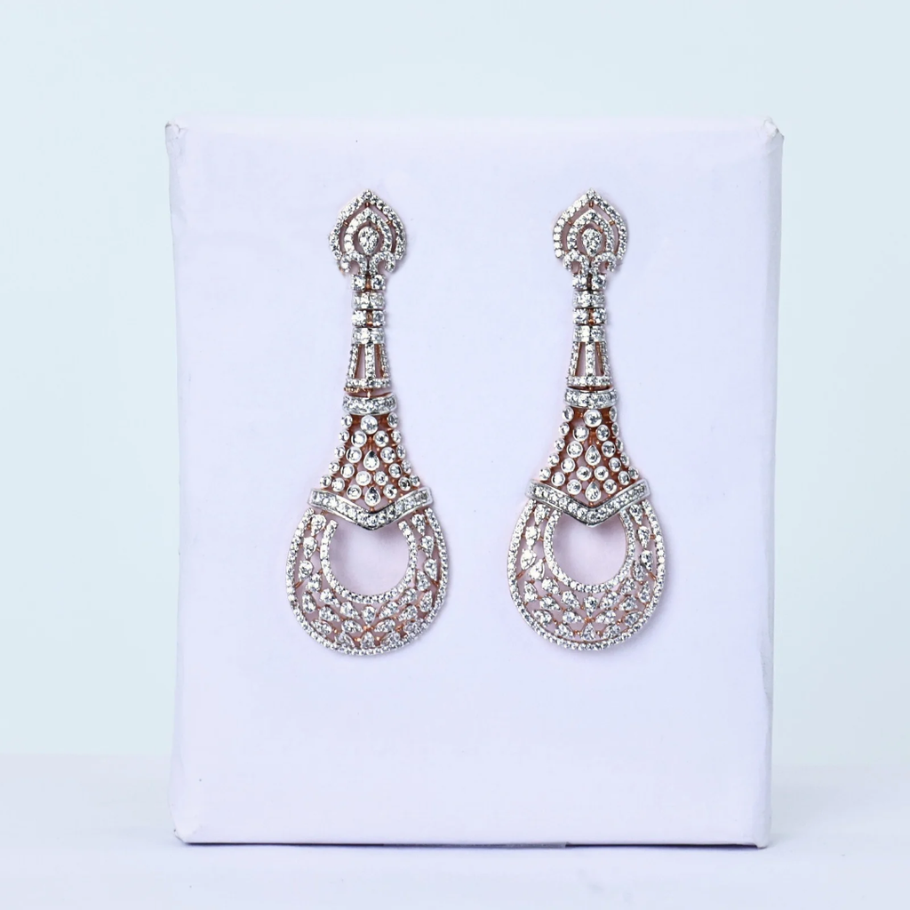 Pair of teardrop earrings
White gold filigree earrings
Diamond earrings on display
Elegant diamond pair
Diamond earrings soft light
Front facing teardrops
Minimalist diamond earrings
Diamond earrings for gifting
Teardrop pattern earrings
Delicate white gold earrings