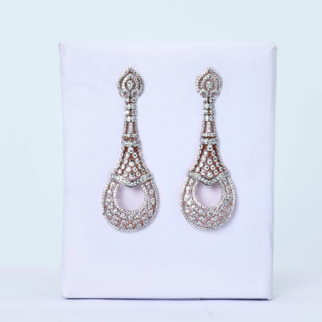 Pair of teardrop earrings
White gold filigree earrings
Diamond earrings on display
Elegant diamond pair
Diamond earrings soft light
Front facing teardrops
Minimalist diamond earrings
Diamond earrings for gifting
Teardrop pattern earrings
Delicate white gold earrings